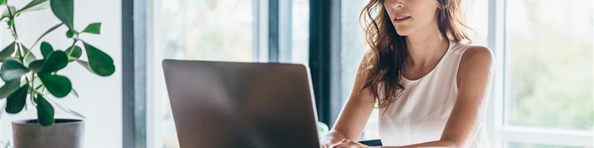 Image shows women using laptop to search quote while drinking a coffee